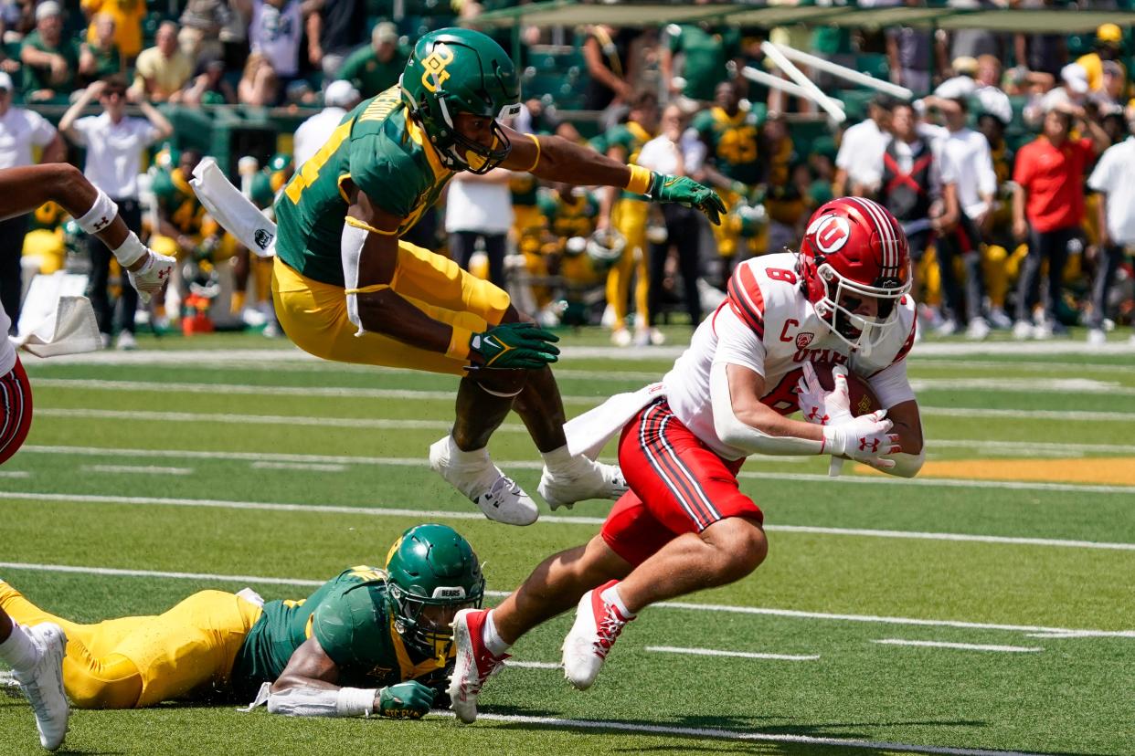Utah Utes safety Cole Bishop (8) makes an interception in front of Baylor Bears wide receiver Josh Cameron (34) during the second half Sept. 9, 2023, at McLane Stadium in Waco, Texas..