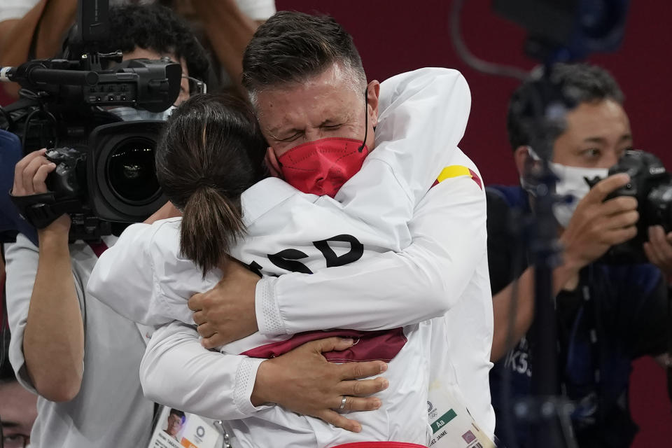 Sandra Sanchez Jaime of Spain hugs her husband and coach Jesus del Moral after winning the women's kata final bout for Karate at the 2020 Summer Olympics, Thursday, Aug. 5, 2021, in Tokyo, Japan. (AP Photo/Vincent Thian)