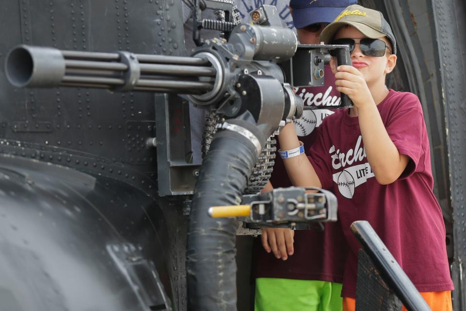 Luke Zemaitis checks out an M134 Minigun while touring a Boeing CH-47 Chinook helicopter during the Experimental Aircraft Association AirVenture on Wednesday, July 28, 2021, at Wittman Regional Airport in Oshkosh, Wis. Attendance at AirVenture is up from years past after the EAA canceled AirVenture 2020 due to the COVID-19 pandemic.Tork Mason/USA TODAY NETWORK-Wisconsin