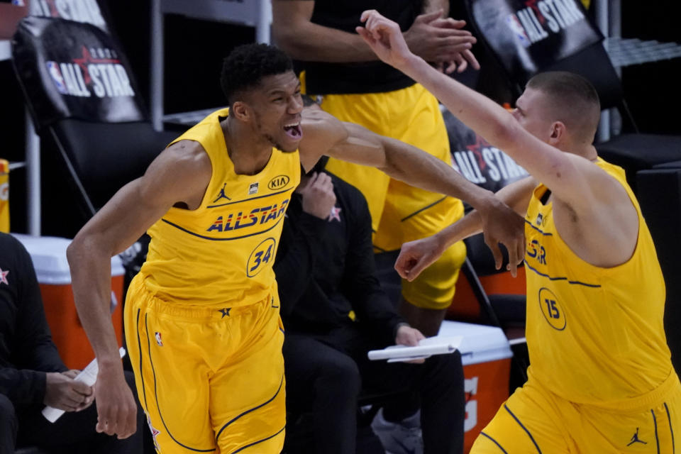 Milwaukee Bucks forward Giannis Antetokounmpo celebrates with Denver Nuggets center Nikola Jokic during the first half of basketball's NBA All-Star Game in Atlanta, Sunday, March 7, 2021. (AP Photo/Brynn Anderson)