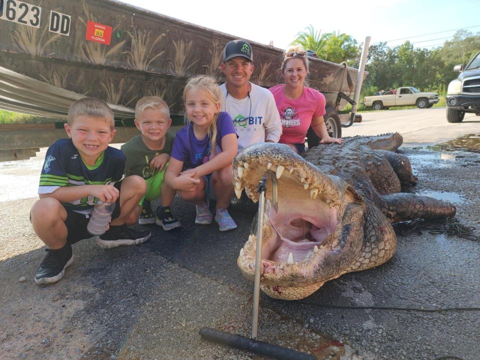 Kevin Brotz and his family pose with the 920lb gator he caught