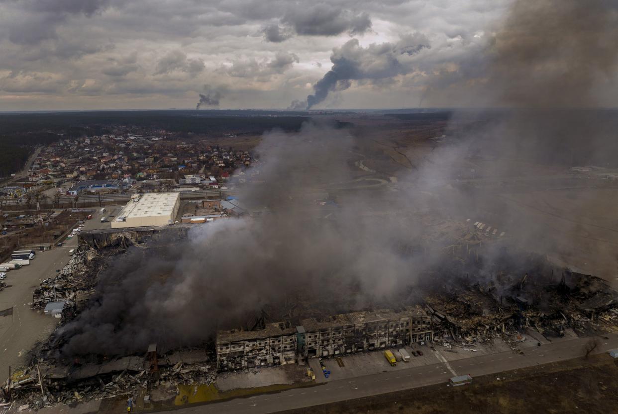 A factory and a store are burning after being bombarded in Irpin, in the outskirts of Kyiv, Ukraine, Sunday, March 6, 2022.