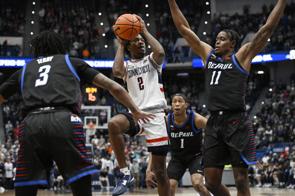 FILE - UConn's Tristen Newton (2) shoots as DePaul's Jalen Terry (3) and Eral Penn (11) defend in the first half of an NCAA college basketball game, Wednesday, March 1, 2023, in Hartford, Conn. While Adama Sanogo, Jordan Hawkins and Andre Jackson are gone, the Huskies return a solid core built around 7-foot-2 sophomore Donovan Clingan and returning starters Alex Karaban and Tristen Newton. (AP Photo/Jessica Hill)