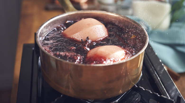 Fruit poaching in pan of red wine