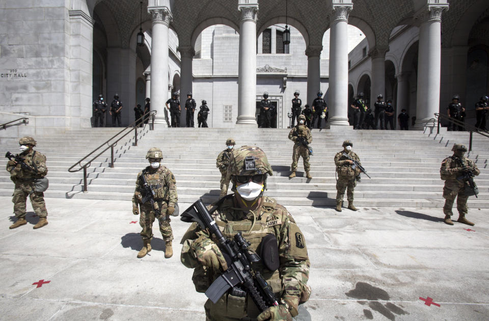 Members of California National Guard stand guard outside the City Hall, Sunday, May 31, 2020, in Los Angeles. The National Guard is patrolling Los Angeles as the city begins cleaning up following a night of violent protests against police brutality. The demonstration Saturday night was sparked by the death of George Floyd, a black man who was killed in police custody in Minneapolis on May 25. (AP Photo/Ringo H.W. Chiu)