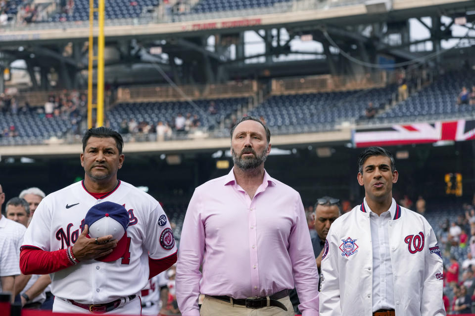 Washington Nationals manager Dave Martinez, left, Stuart Taylor, who served as a Warrant Officer in the British Army, and British Prime Minister Rishi Sunak, stand during the playing of the national anthems of both countries, before a baseball game between the Washington Nationals and the Arizona Diamondbacks at Nationals Park, Wednesday, June 7, 2023, in Washington. In celebration of the recent coronation of King Charles III and the enduring partnership between the United States and United Kingdom, the Washington Nationals are having "UK-US Friendship Day." (AP Photo/Alex Brandon)