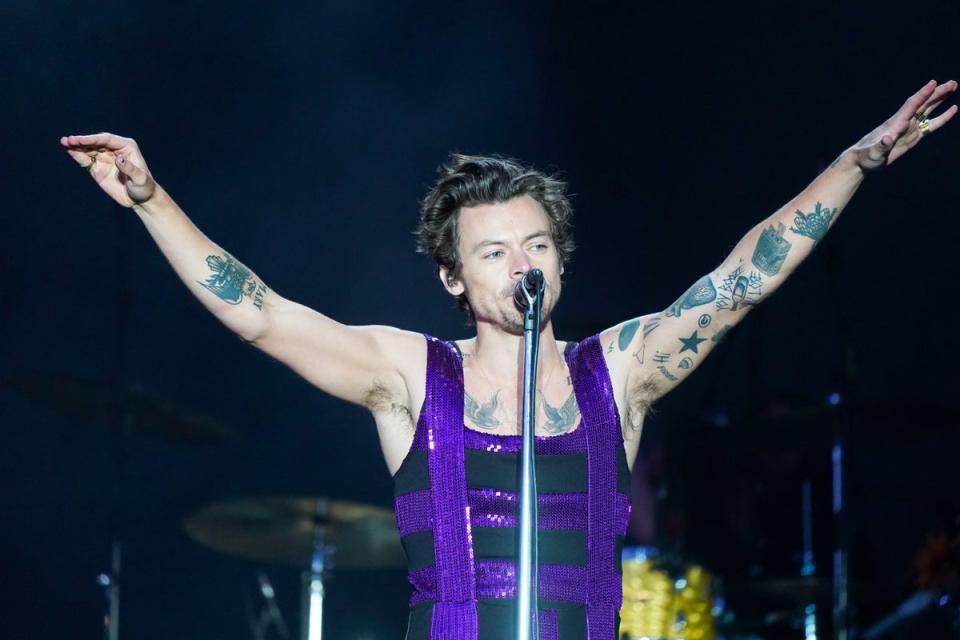 Harry Styles performing wearing a sequined flared jumpsuit in 2022 (PA)