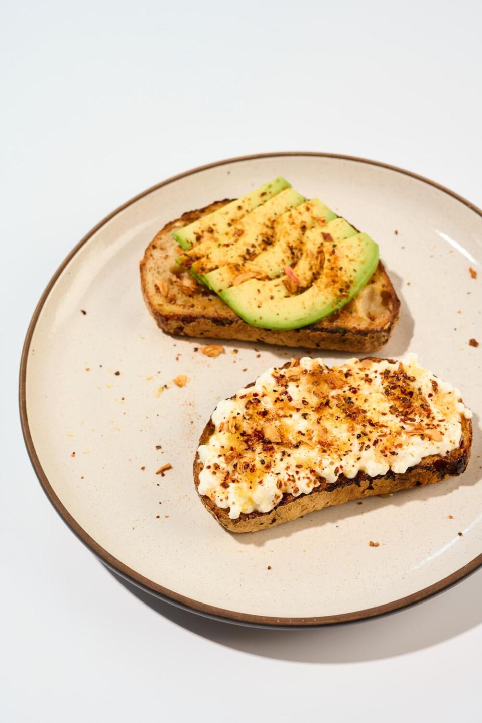 Avocado toast and cottage cheese toast on a plate sprinkled with spice blend California Heat