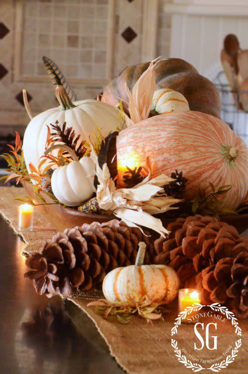 <p>A burlap runner, votive candles, and a large wooden bowl brimming with pine cones, gourds, ornamental corn, and turkey feathers give this table an abundant look. </p><p><strong>Get more details at <a rel="nofollow noopener" href="http://www.stonegableblog.com/stonegable-fall-house-tour/" target="_blank" data-ylk="slk:Stone Gable;elm:context_link;itc:0;sec:content-canvas" class="link ">Stone Gable</a>.</strong> </p>