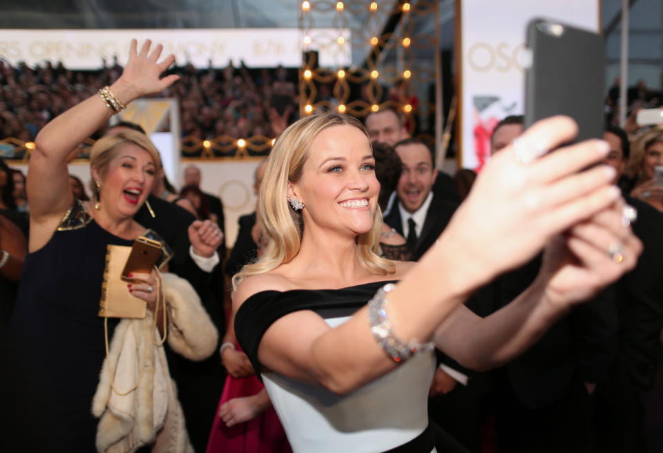 Reese Witherspoon takes selfies with enthusiastic fans all while perfectly posing for photos herself. Now that’s the true mark of an expert.