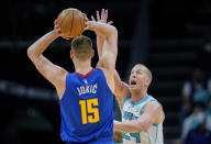 Charlotte Hornets center Mason Plumlee, right, guards against Denver Nuggets center Nikola Jokic (15) during the first half of an NBA basketball game on Monday, March 28, 2022, in Charlotte, N.C. (AP Photo/Rusty Jones)