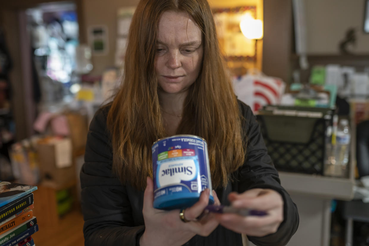 Katie Wussler checks the lot number on a donated can of Similac baby formula on May 12, 2022 in Portland, Oregon. (Photo by Nathan Howard/Getty Images)