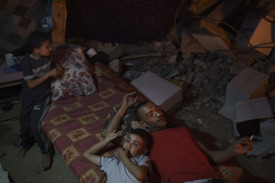 Family members lie inside a makeshift tent built among the rubble of their home, destroyed by an airstrike in Beit Lahiya, northern Gaza Strip, Monday, June 14, 2021. (AP Photo/Felipe Dana)