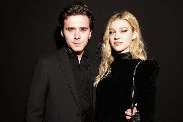 <p>Swan Gallet/Getty</p> Brooklyn Beckham and Nicola Peltz attend the Saint Laurent show during Paris Fashion Week