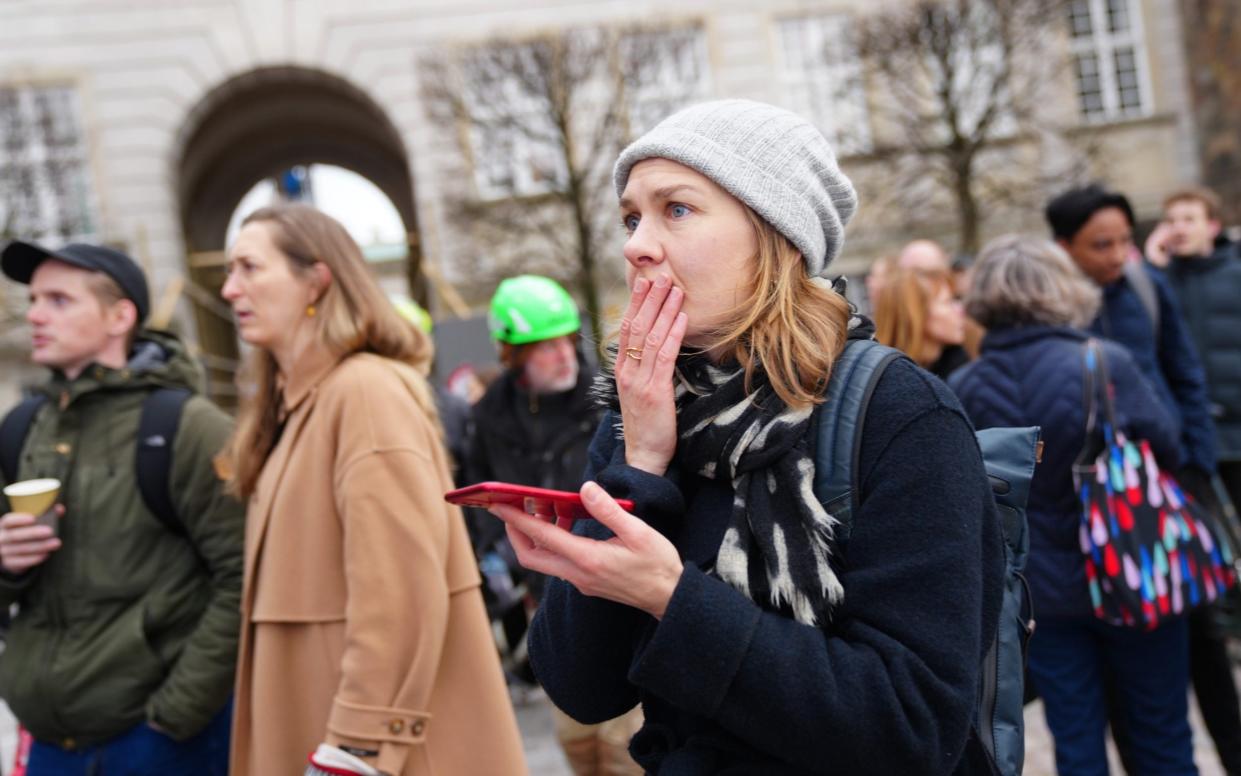 A local reacts as a fire burns the old Stock Exchange (Boersen) in Copenhagen, Denmark, 16 April 2024.