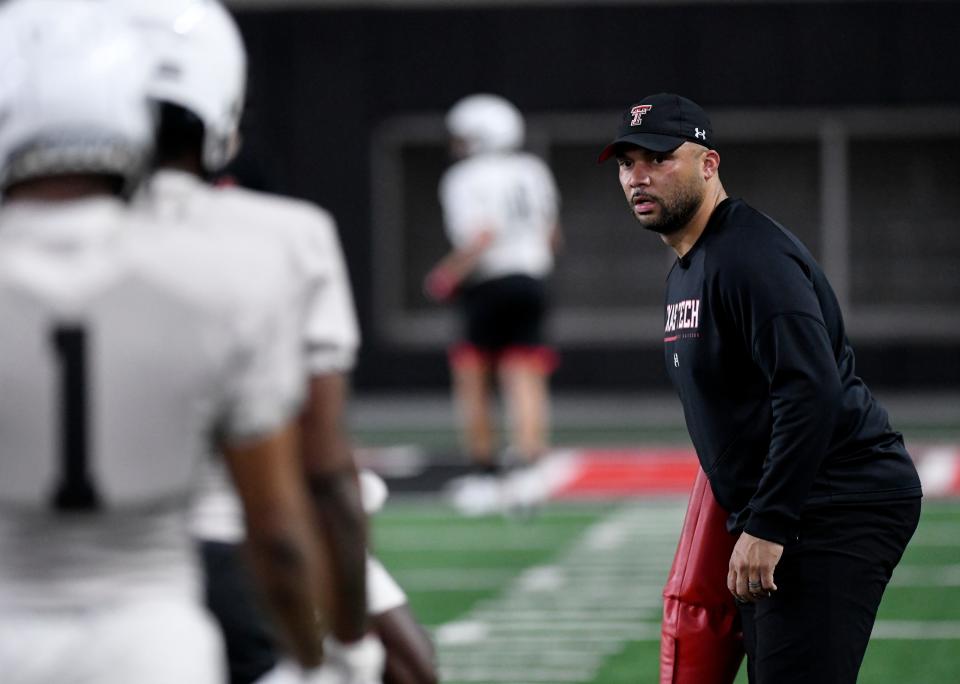 Texas Tech assistant coach Justin Johnson, right, puts his receivers through their paces during a session of spring football practice.