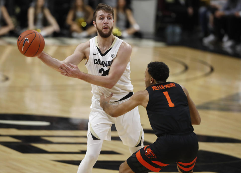 Colorado forward Lucas Siewert, back, passes the ball as Oregon State guard Sean Miller-Moore in the second half of an NCAA college basketball game Sunday, Jan. 5, 2020, in Boulder, Colo. Oregon State came from behind to win 76-68. (AP Photo/David Zalubowski)