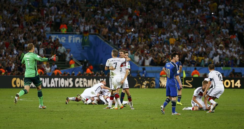 Argentina's Lionel Messi reacts as Germany players celebrate after winning their 2014 World Cup final at the Maracana stadium in Rio de Janeiro July 13, 2014. REUTERS/Damir Sagolj (BRAZIL - Tags: TPX IMAGES OF THE DAY SOCCER SPORT WORLD CUP)