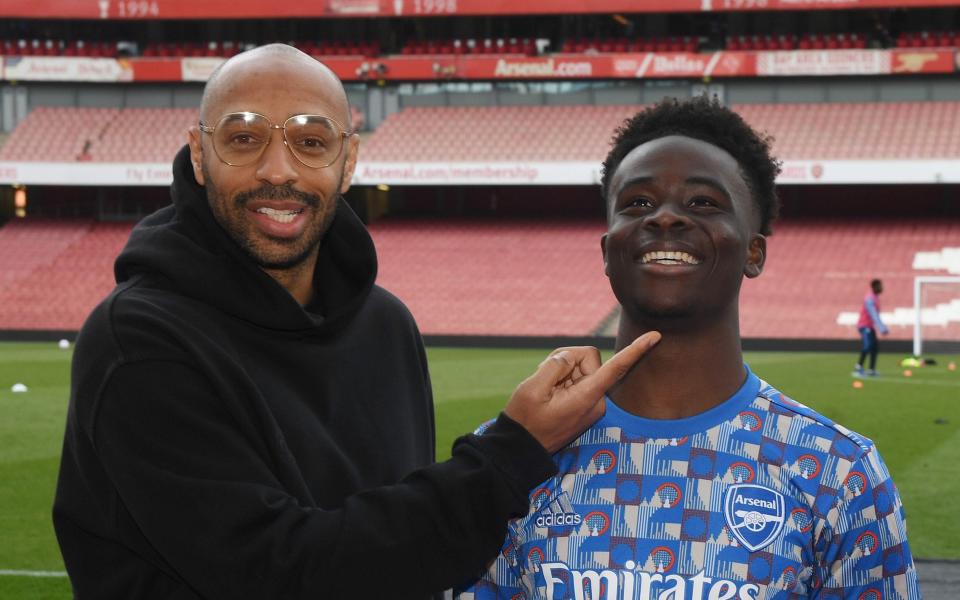 Ex Arsenal player Thierry Henry with (R) current player Bukayo Saka after the Premier League match between Arsenal and Manchester United at Emirates Stadium on April 23, 2022 - Stuart MacFarlane/Getty Images