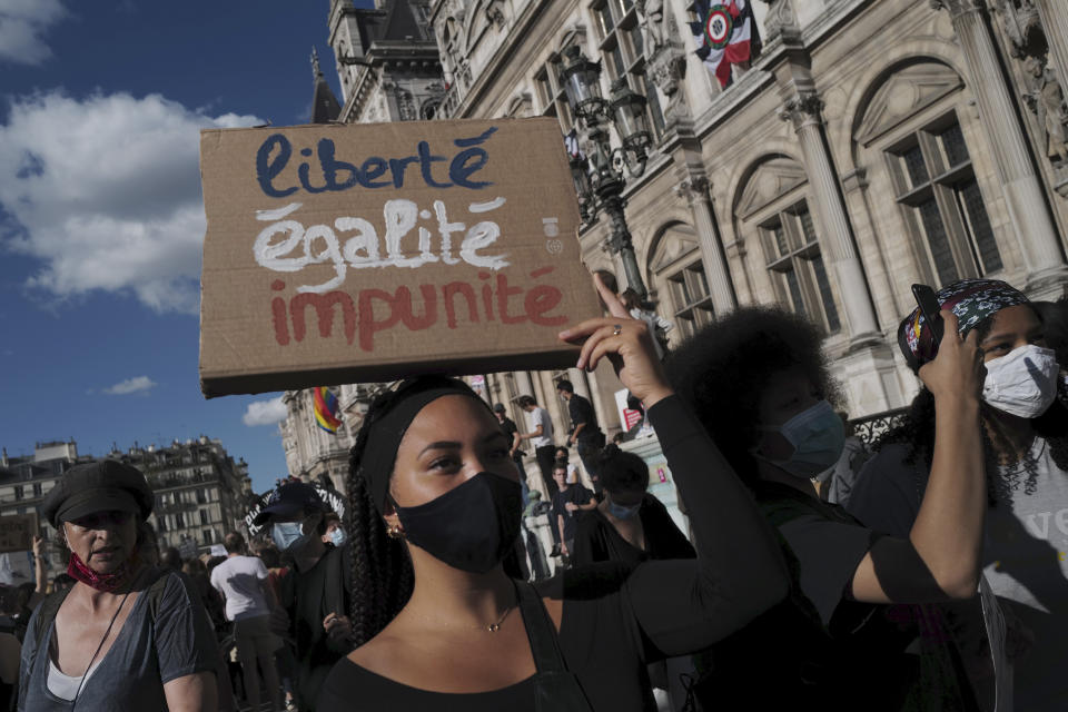 Women's rights activists protest against French President Emmanuel Macron's appointment of an interior minister who has been accused of rape and a justice minister who has criticized the #MeToo movement, in front of Paris city hall, in Paris, France, Friday, July 10, 2020. The French government said it remains committed to gender equality and defended the new ministers, stressing the presumption of innocence. Gerald Darmanin, Interior Minister, firmly denies the rape accusation, and an investigation is underway. New Justice Minister Eric Dupond-Moretti is a lawyer who has defended a government member accused of rape and sexual assault, and has ridiculed women speaking out thanks to the #MeToo movement. (AP Photo/Francois Mori)