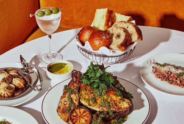 <p>Alex Lau</p> Dinner at Raf's, clockwise from left: escargot, P's martini, "daily breads" with butter and olive oil, steak tartare, half chicken with salsa verde.