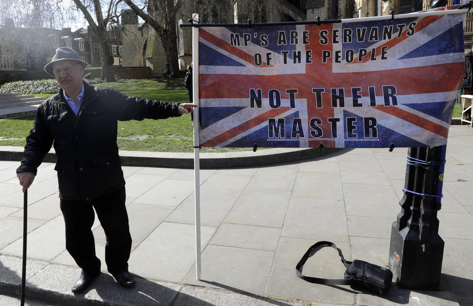 A campaigner holds a banner outside Parliament in London, Monday, March 25, 2019. British Prime Minister Theresa May is under intense pressure Monday to win support for her Brexit deal to split from Europe. (AP Photo/Kirsty Wigglesworth)