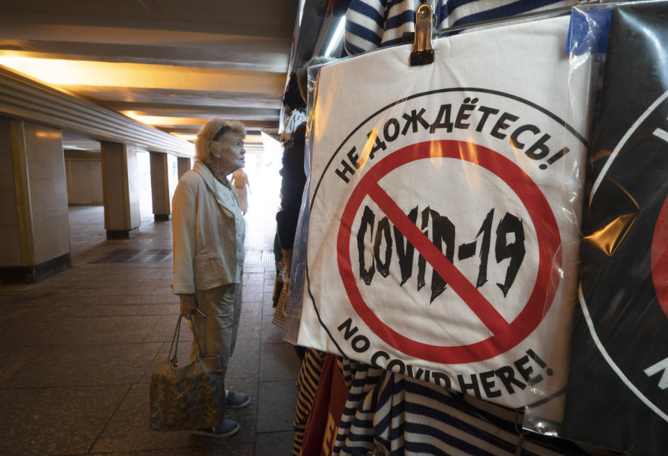 A woman looks at souvenirs in a souvenir stall in an underpass, with a T-shirt reading "That's not gonna happen!" in the foreground, amid the ongoing COVID-19 pandemic in St. Petersburg, Russia, Wednesday, June 10, 2020. (AP Photo/Dmitri Lovetsky)