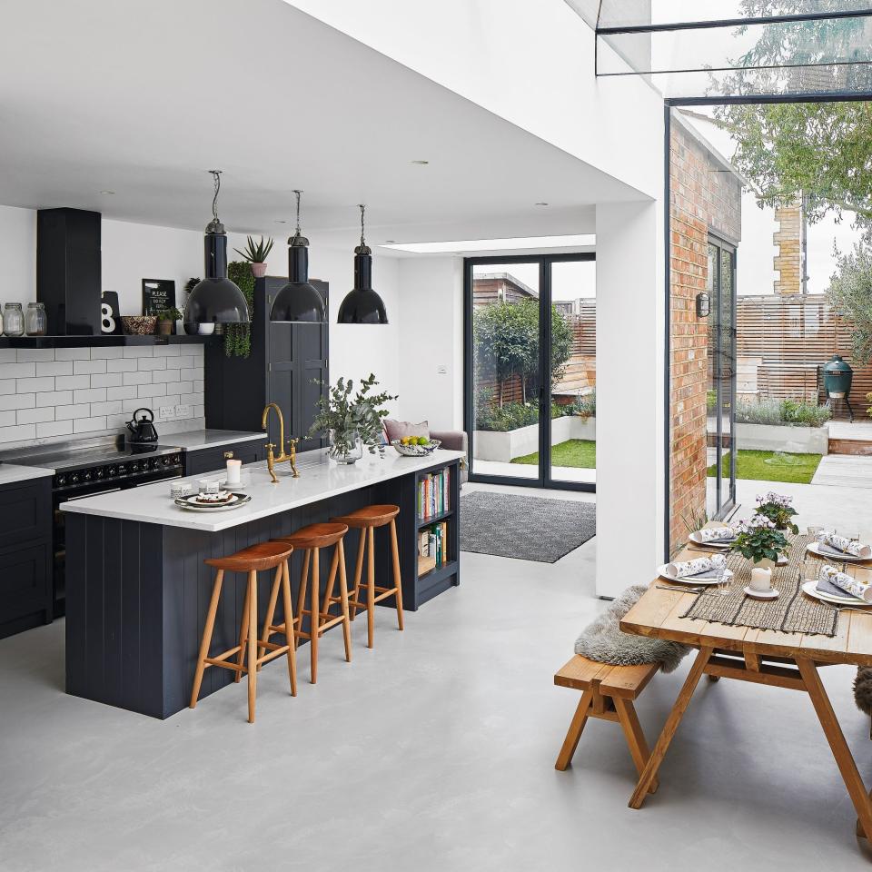 Large kitchen with jutting wall and glass doors with dining area