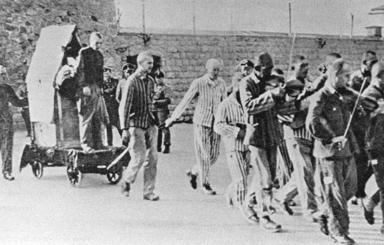 Prisoners are forced to play music as they lead a fellow prisoner to his execution at the Mauthausen concentration camp in Austria. <a href="https://www.gettyimages.com/detail/news-photo/prisoners-are-forced-to-give-company-to-fellow-sufferers-news-photo/503021537?adppopup=true" rel="nofollow noopener" target="_blank" data-ylk="slk:Votava/Imagno via Getty Images;elm:context_link;itc:0;sec:content-canvas" class="link ">Votava/Imagno via Getty Images</a>