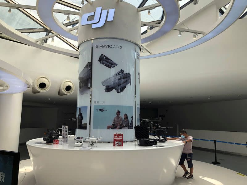 FILE PHOTO: Man wearing a face mask following the coronavirus disease (COVID-19) outbreak is seen at a counter displaying drones and other products at DJI's flagship store in Shenzhen