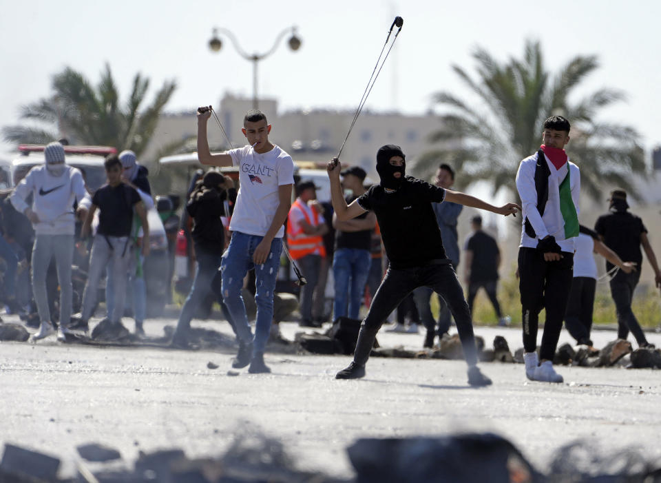 Palestinians throw stones at Israeli troops during clashes after a rally marking74h anniversary of what the Palestinians call the "Nakba," or "catastrophe" referring to their uprooting in the war over Israel's 1948 creation, in the West Bank city of Ramallah, Sunday, May 15, 2022. (AP Photo/Majdi Mohammed)