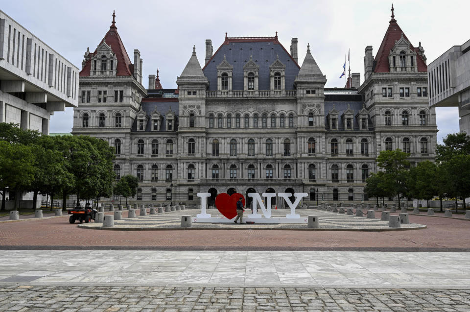 FILE - A maintenance worker cleans a sign outside the New York state Capitol as Assembly members return Tuesday, June 20, 2023, in Albany, N.Y. The New York state Legislature on Wednesday, Feb. 28, 2024, approved a Democrat-drawn congressional map that gives the party a modest boost in a few battleground districts, helping their candidates in a heavily contested election year when House races in the state could determine control of Congress. (AP Photo/Hans Pennink, File)