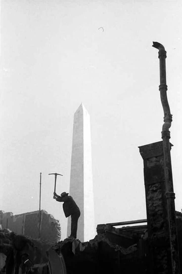 Un trabajador rompe con su pico un edificio situado cerca del Obelisco, para la construcción de la avenida 9 de Julio