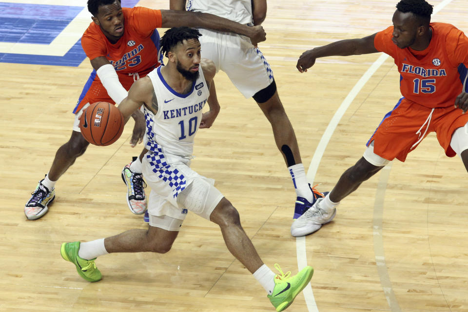 Kentucky's Davion Mintz (10) drives near Florida's Scottie Lewis (23) and Osayi Osifo (15) during the second half of an NCAA college basketball game in Lexington, Ky., Saturday, Feb. 27, 2021. (AP Photo/James Crisp)