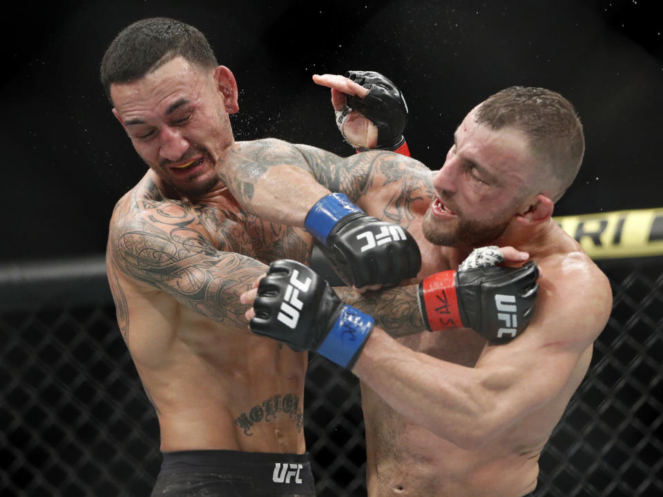 Alexander Volkanovski lands an elbow to Max Holloway in a mixed martial arts featherweight championship bout at UFC 245, Saturday, Dec. 14, 2019, in Las Vegas. (AP Photo/John Locher)