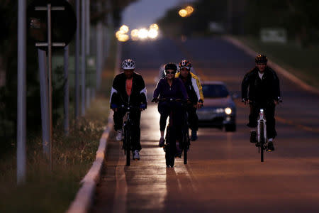 Brazil's President Dilma Rousseff rides her bicycle accompanied by bodyguards near the Alvorada Palace in Brasilia, Brazil April 15, 2016. REUTERS/Ueslei Marcelino