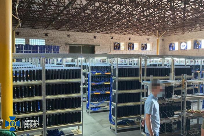 A man walks through shelves of CPUs in an illegal crypto mine in the Ukraine
