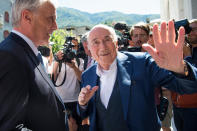 The former Fifa President, Joseph Blatter, center, surrounded by media representatives, waves to the press in front of the Swiss Federal Criminal Court in Bellinzona, Switzerland, at the last day of the trail, after the verdict has been announced, Friday, July 8, 2022. The trial ended with an acquittal. Blatter and Michel Platini, former president of the the European Football Association (Uefa), stood trial before the Federal Criminal Court over a suspicious two-million payment. The Federal Prosecutor's Office accused them of fraud. The defense spoke of a conspiracy. (Ti-Press/Alessandro Crinari/Keystone via AP)