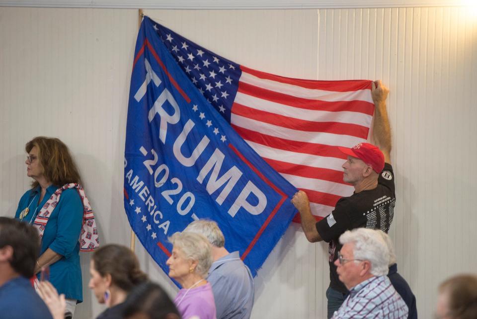 A man holds up a flagpole with both an American flag and a Donald Trump campaign flag at the 1st District GOP convention at the Lions Club for the Blind in Waycross on Saturday. 