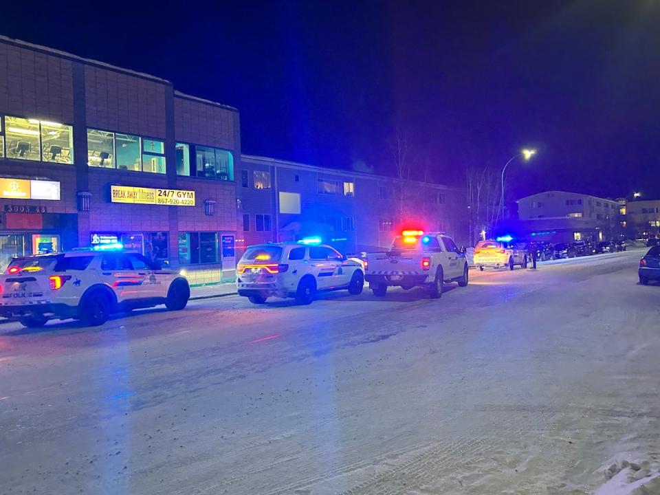 RCMP vehicles with lights flashing sit outside Franklin House in Yellowknife last Thursday after responding to reports of someone threatening people with a knife. (Mah Noor Mubarik/CBC - image credit)