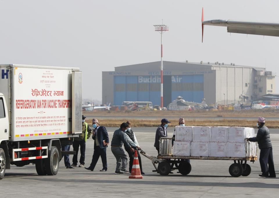 FILE - In this Jan. 21, 2021, file photo, Nepalese airport ground staffs pulls boxes of AstraZeneca vaccine, manufactured under license by Serum Institute of India, arrive at Tribhuwan International Airport in Kathmandu, Nepal. The COVAX global initiative is providing vaccines to poorer countries lacking the clout to negotiate for them on their own, but it has only cleared 2 million doses in the past two weeks because nearly all deliveries through the program are blocked until as late as June. On March 25, COVAX announced a major setback in its vaccine rollout because a surge in infections in India had caused the Serum Institute of India to cater to domestic demand, resulting in a delay in global shipments of up to 90 million doses. (AP Photo/Niranjan Shrestha, File)