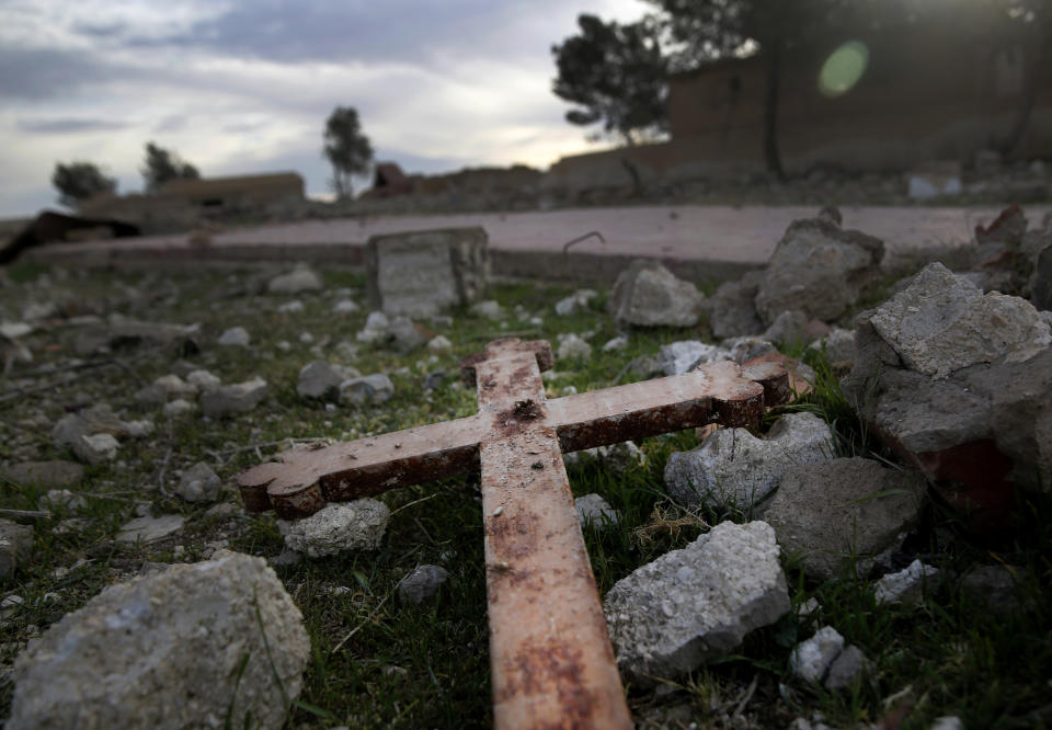 FILE - This April 1, 2018 file photo, shows a cross that lies in the rubble of a destroyed church that was blown up by Islamic State militants in 2015, in the deserted village of Tal Jazeera, northern Syria. The Qatar-based Syrian Network for Human Rights, a Syrian war monitor associated with the opposition said in its report Monday, Sept. 9, 2019, that over 120 Christian places of worship have been damaged or destroyed by all sides in the country’s eight-year conflict. (AP Photo/Hussein Malla, File)