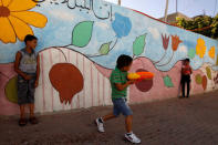 FILE PHOTO: Local kids play next to a wall painted with graffiti in El Bustan (King's Garden) part of Silwan neighborhood in East Jerusalem June 21, 2010. REUTERS/ Ronen Zvulun/File Photo