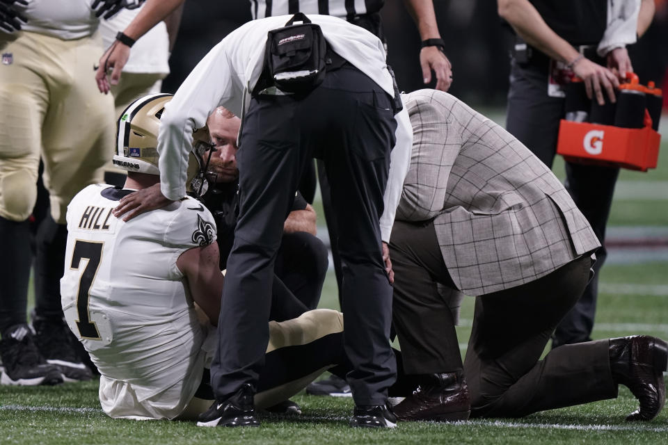 New Orleans Saints quarterback Taysom Hill (7) is helped after injury against the Atlanta Falcons during the first half of an NFL football game, Sunday, Jan. 9, 2022, in Atlanta. (AP Photo/Brynn Anderson)