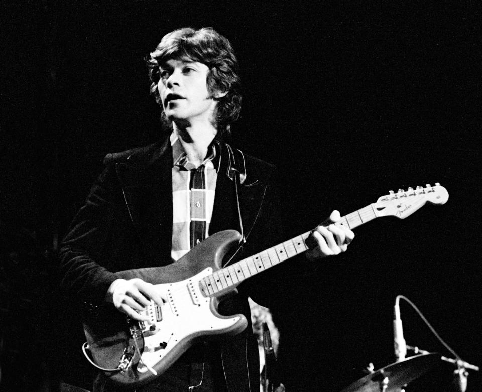 Robbie Robertson playing a guitar