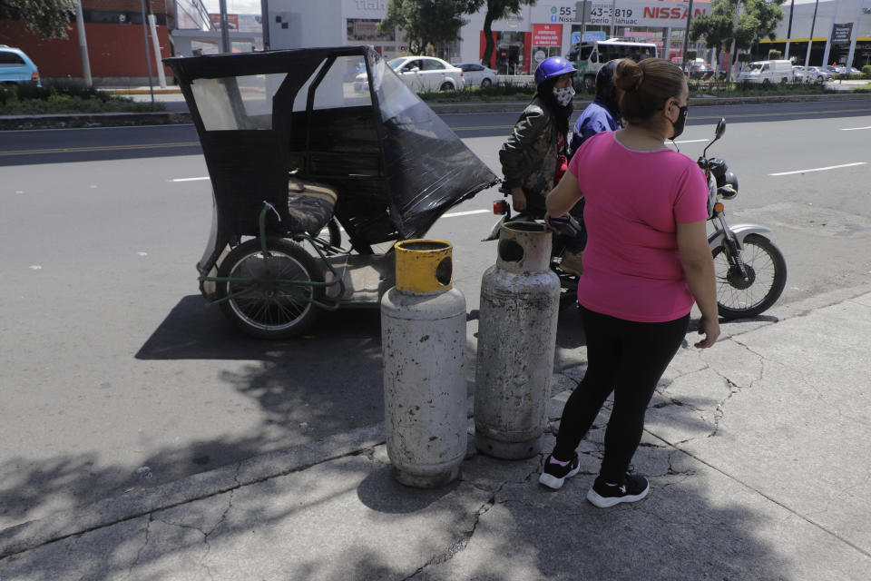 A woman rides a motorbike taxi to an LP gas distribution centre in Mexico City to refill her tanks after the Valle de Mexico Gas Dealers' Union went on strike in protest against the maximum prices set by the Federal Government during the COVID-19 health emergency in Mexico. (Photo by Gerardo Vieyra/NurPhoto via Getty Images)