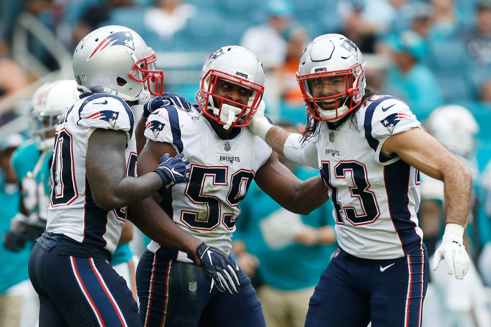 Albert McClellan (59) and Ramon Humber (50) of the Patriots celebrate with Nate Ebner after blocking a punt against Miami. (Getty Images)