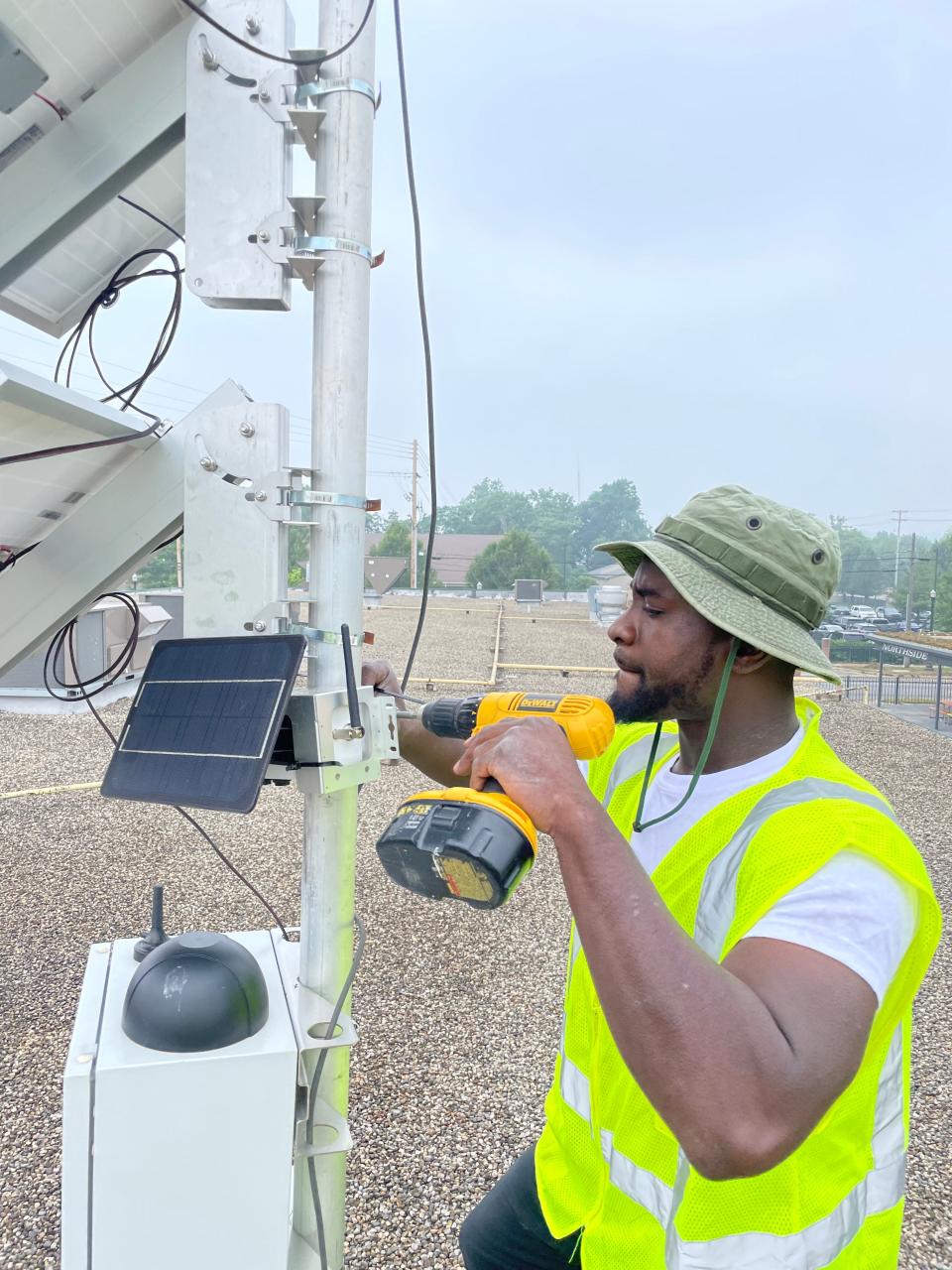 Robert Simmons installs an air-quality monitor for the environmental tech company JustAir on a pole in Kalamazoo. The company is contracting with Wayne County on a three-year effort to improve the quality of the air in the county's 43 communities.