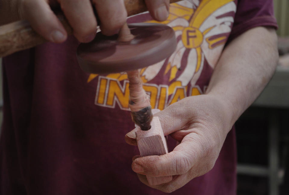 Mark Pederson "Swift Horse," a member of the Sisseton-Wahpeton Dakota Nation and a fourth generation quarrier, demonstrates how to carve a pipe from a unique variety of pipestone called catlinite at the Pipestone National Monument Museum on Wednesday, May 3, 2023, in Pipestone, Minn. The pipes are used to smoke tobacco during prayer, ritual and civil ceremonies. It is thought that those prayers are carried to the Great Spirit on smoke. (AP Photo/Jessie Wardarski)