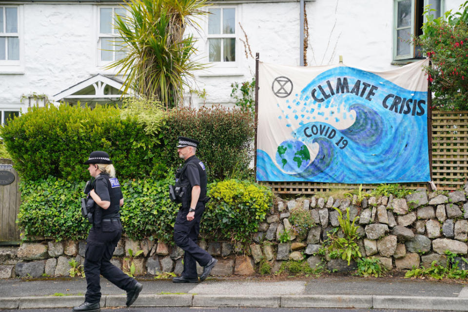 Police officers walk past a banner regarding climate change in Carbis Bay, ahead of the G7 summit in Cornwall. Picture date: Thursday June 10, 2021.<span class="copyright">Aaron Chown—PA Wire/PA Images</span>